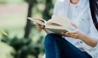 chicas en jardin con libro rodilla