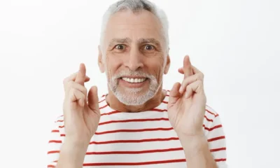 hombre anciano cruza dedos sonrie
