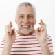 hombre anciano cruza dedos sonrie