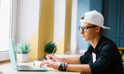 joven con gorra gafas delante pc