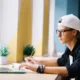 joven con gorra gafas delante pc