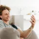 joven en sofa viendo video en movil