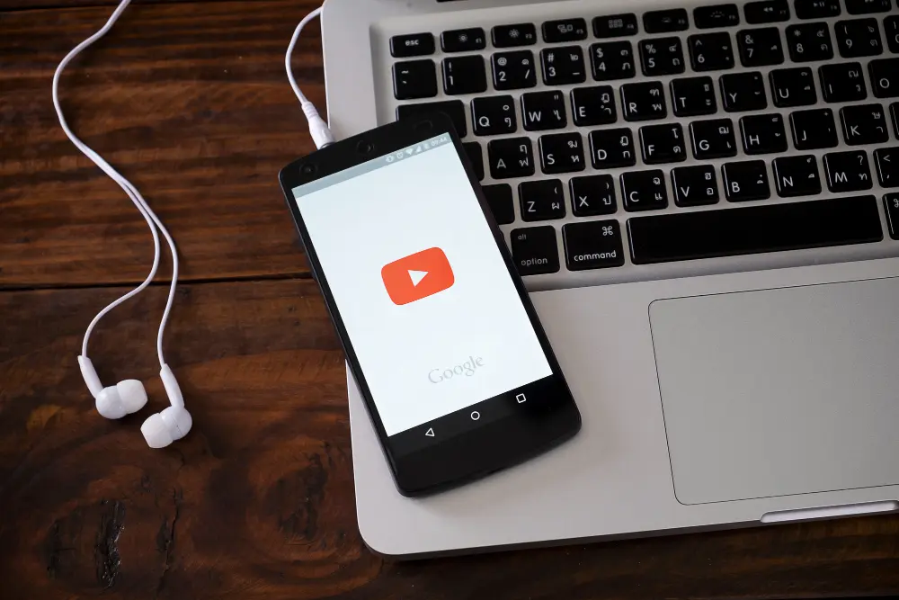 movil con logo youtube sobre portatil