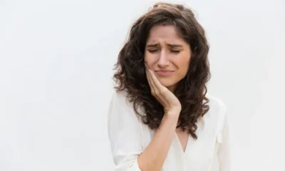 mujer se toca donde tiene dolor de muelas