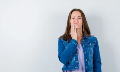 mujer toca encias dolidas