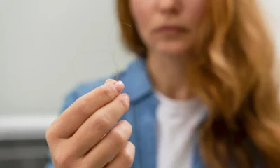 mujer tiene en mano pelo caido