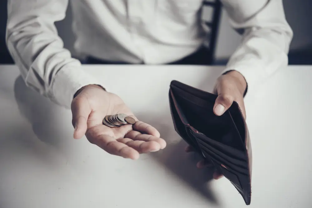hombre en camisa muestra cartera sin dinero