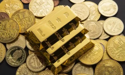 algunos lingotes de oro sobre monedas doradas
