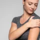 chica con dolor de omalgia en el hombro