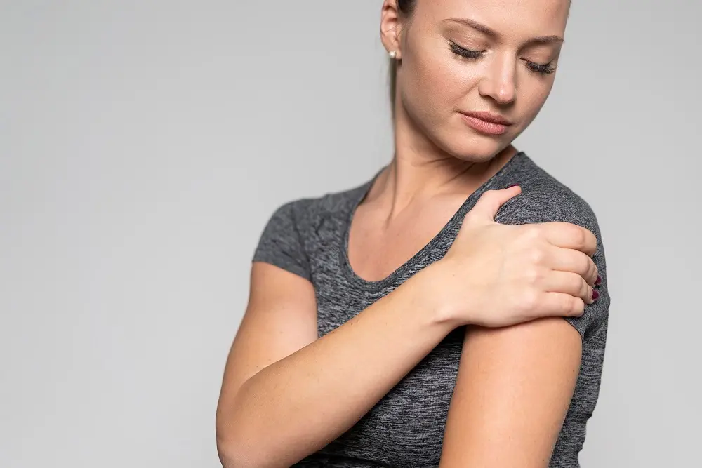 chica con dolor de omalgia en el hombro