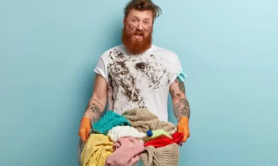 chico con barba lleva mucha ropa sucia de pintura