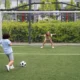 niño tira gol contra niña portería futbol