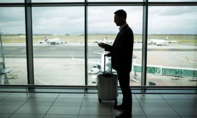 pasajero hombre mirando fuera de la ventana de un aeropuerto