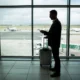 pasajero hombre mirando fuera de la ventana de un aeropuerto