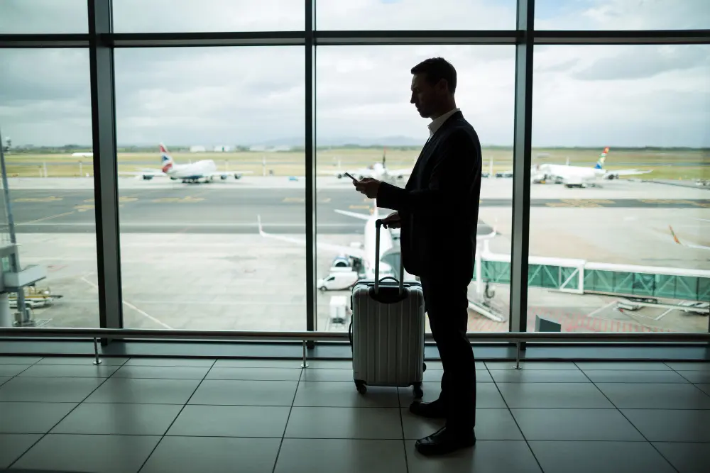 pasajero hombre mirando fuera de la ventana de un aeropuerto
