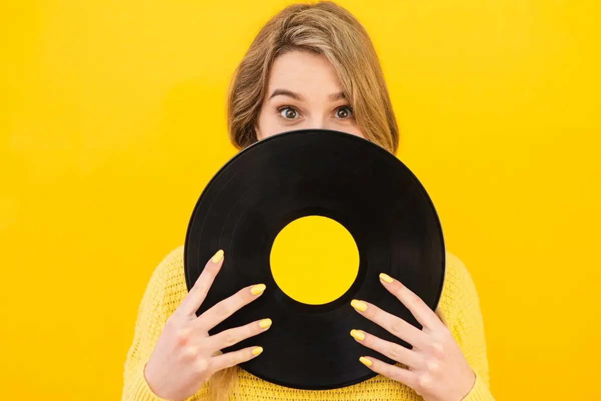 chica delante parede amarillo con vinilo delante