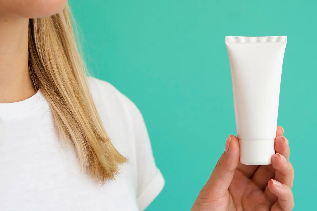chica rubia con una crema para hemorroides