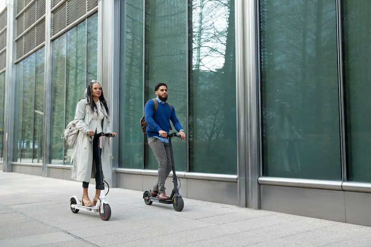 dos chicos van en patinetes electricos