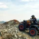 hombre con quad escala una montaña