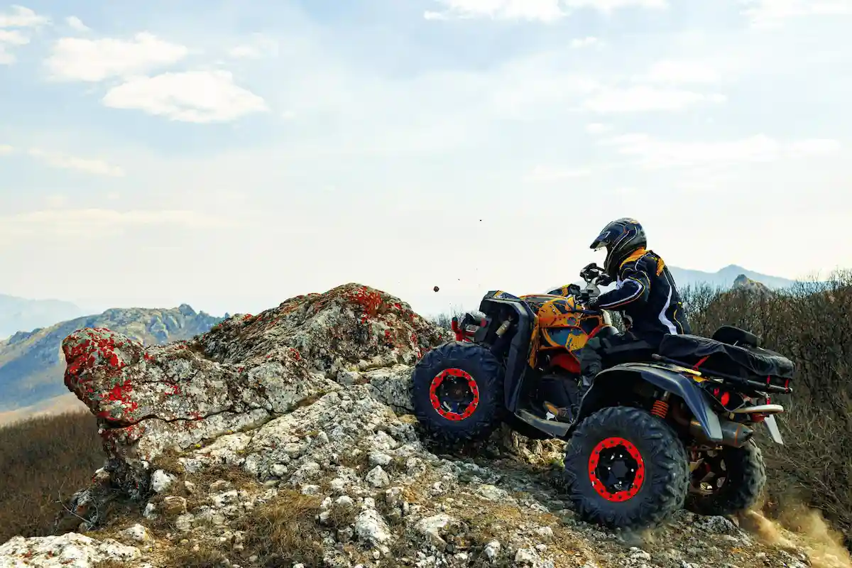hombre con quad escala una montaña