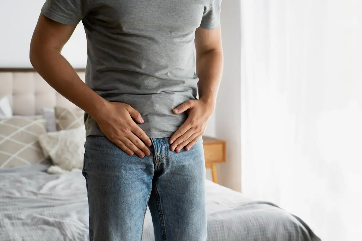 hombre se toca hernias inguinales
