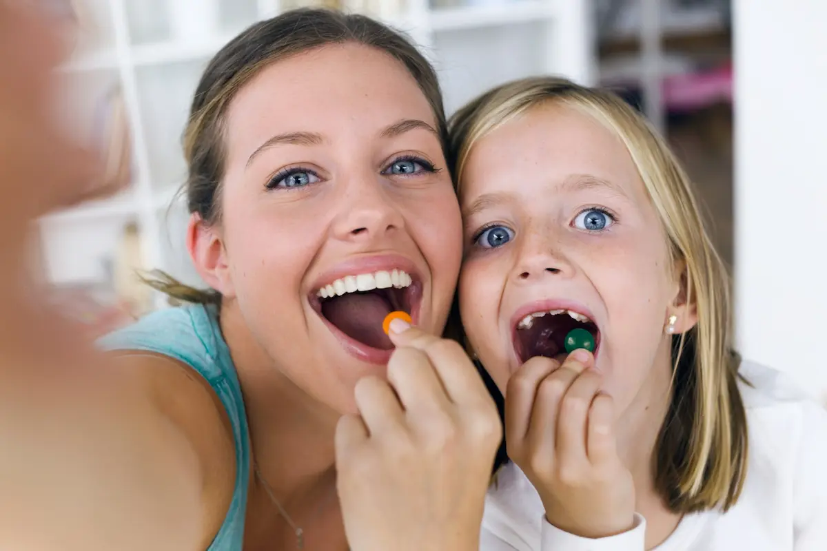 mama sonrie con hija sin varios dientes