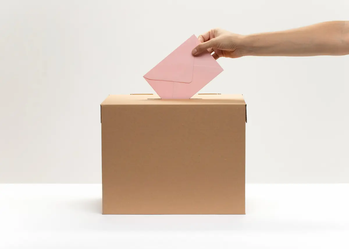 mano de mujer mientras vota papeleta