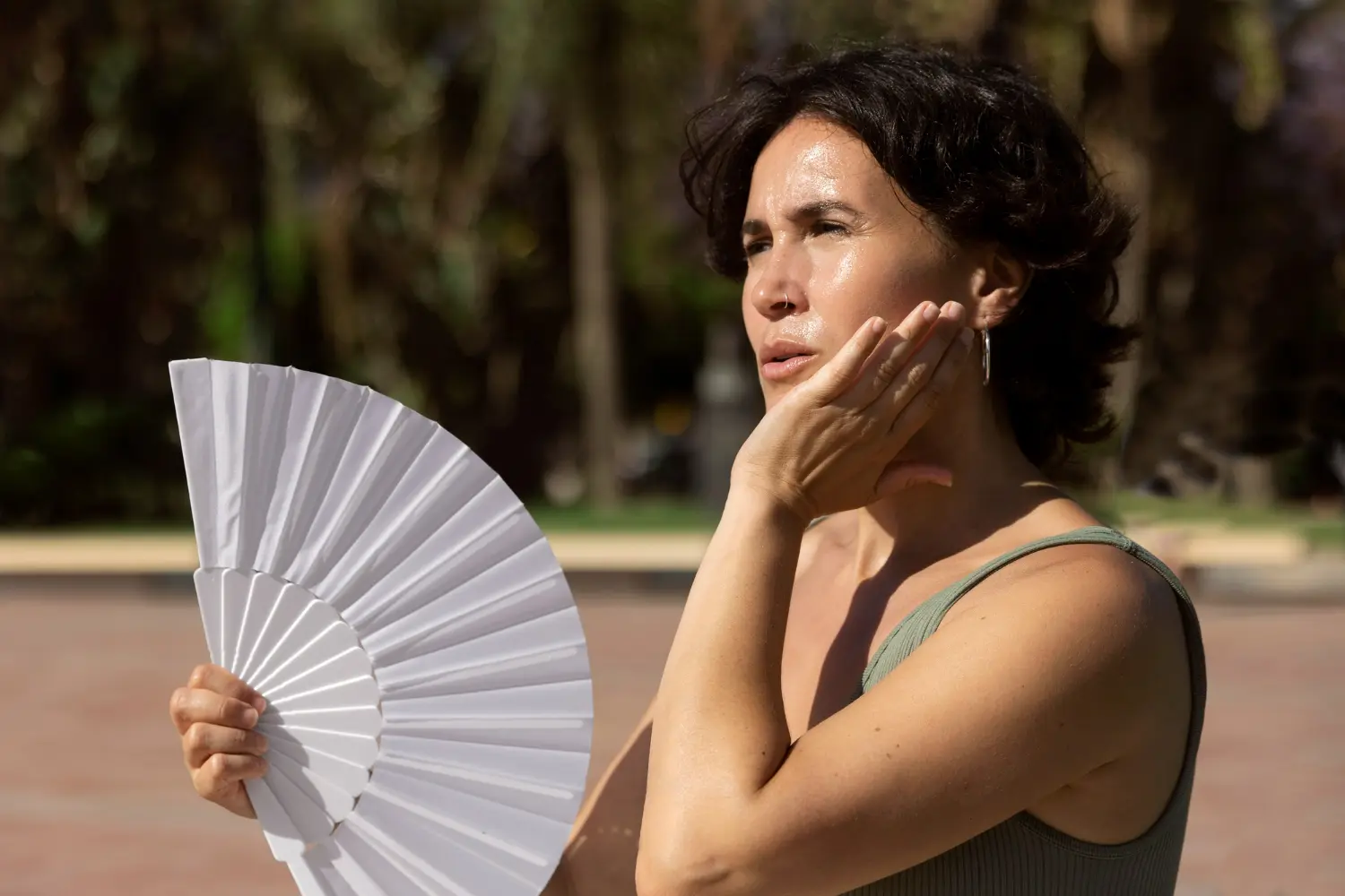 mujer con abanico sufre ola de calor