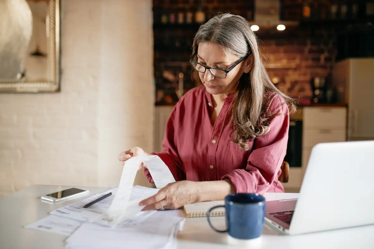 mujer con gafas controla un recibo bssg