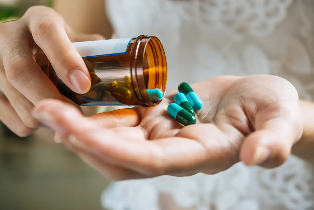 mujer deja caer medicinas en su mano