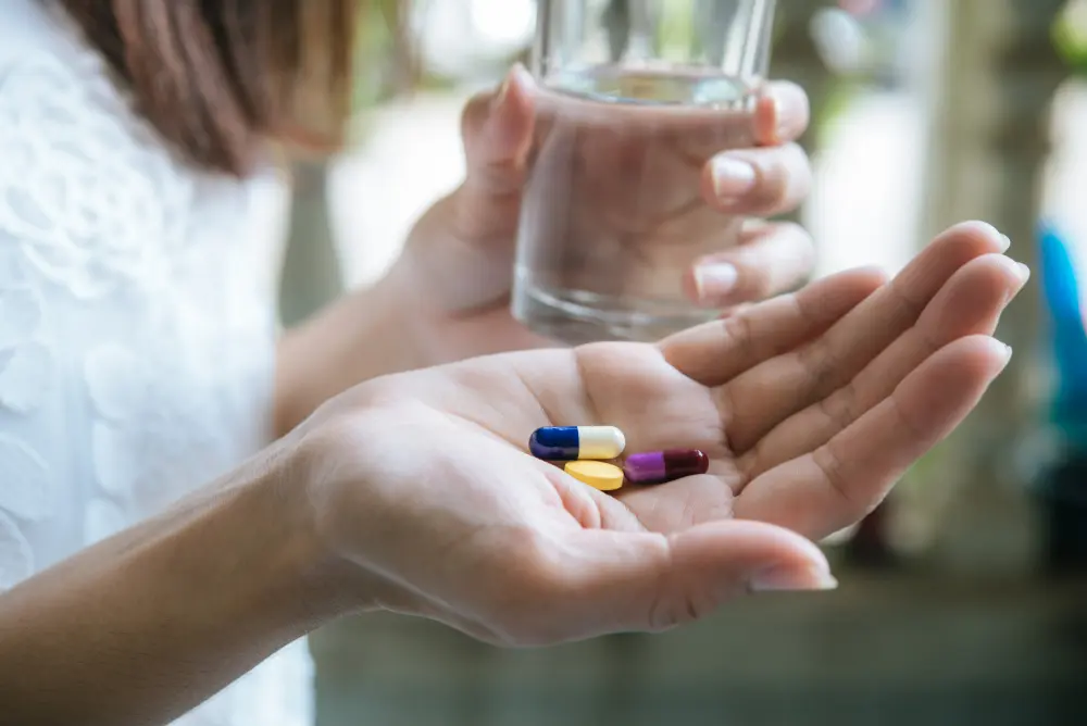 mujer tomando pastillas de finocarbo