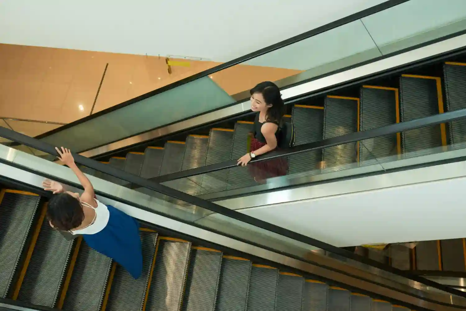 mujeres mientras bajan y suben de escalera movil