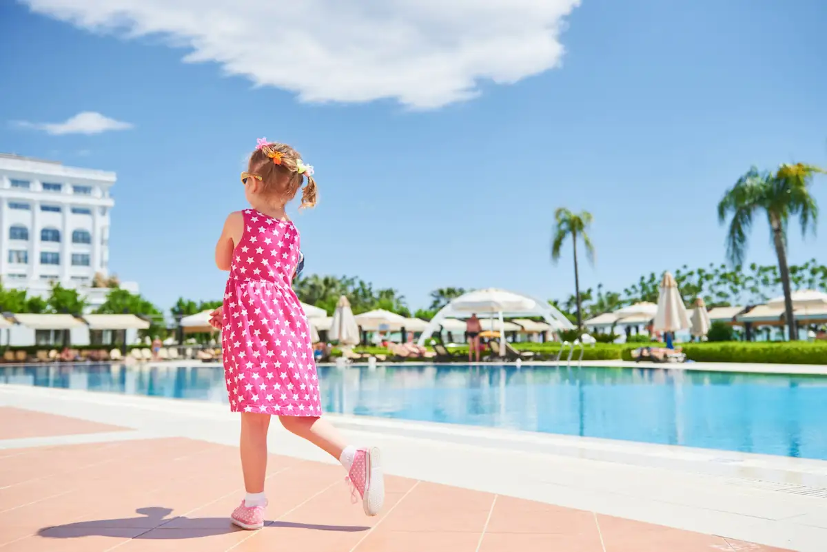 niña correteando en piscina de un hotel