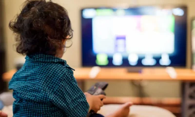 niño delante a tv con mando en mano