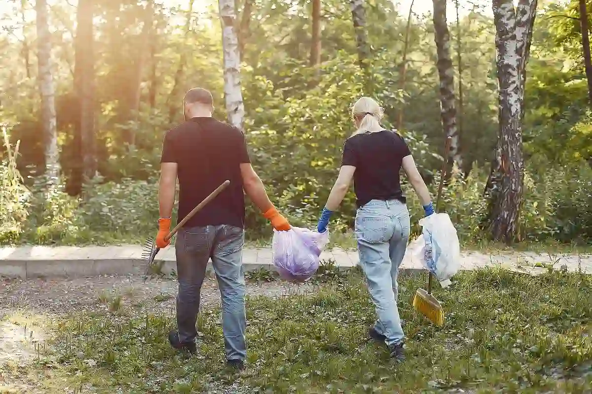 pareja recoge basura en bolsas de basura en el parque