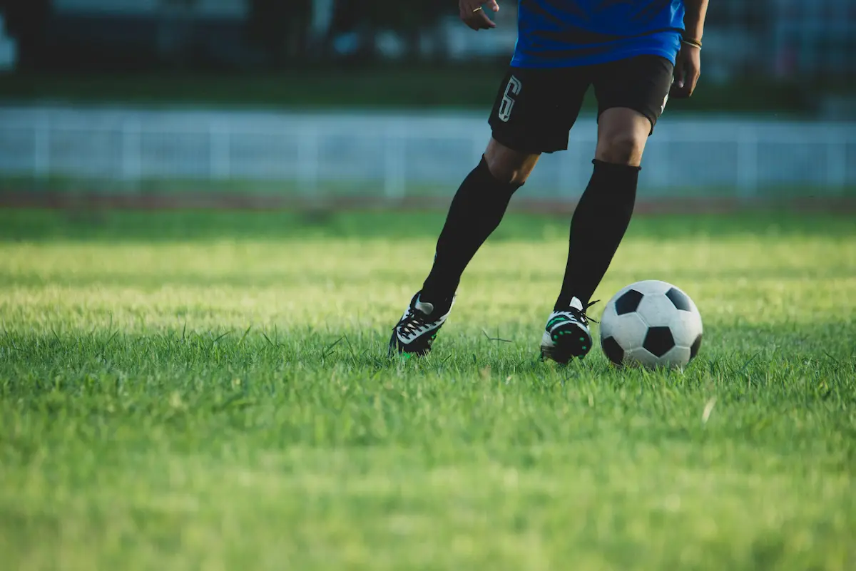 piernas de futbolista sobre campo