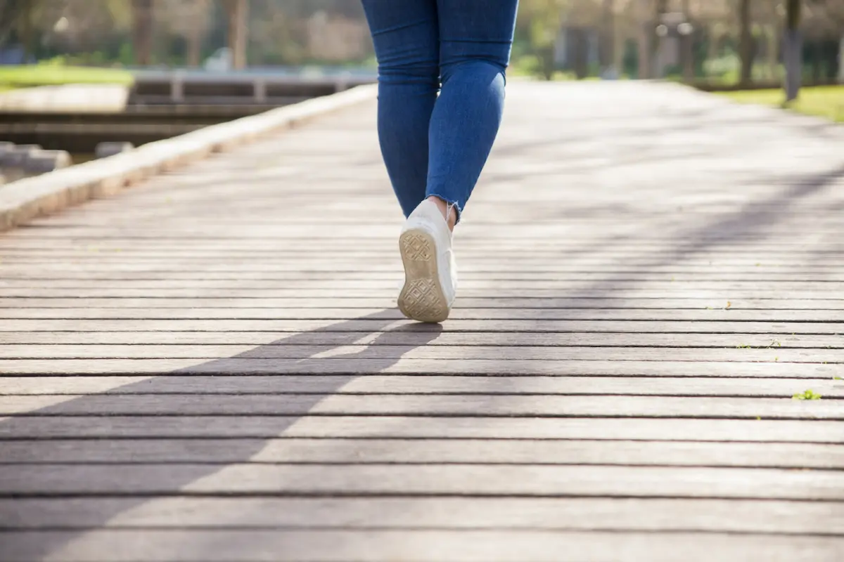 piernas de una mujer que camina bajo el sol
