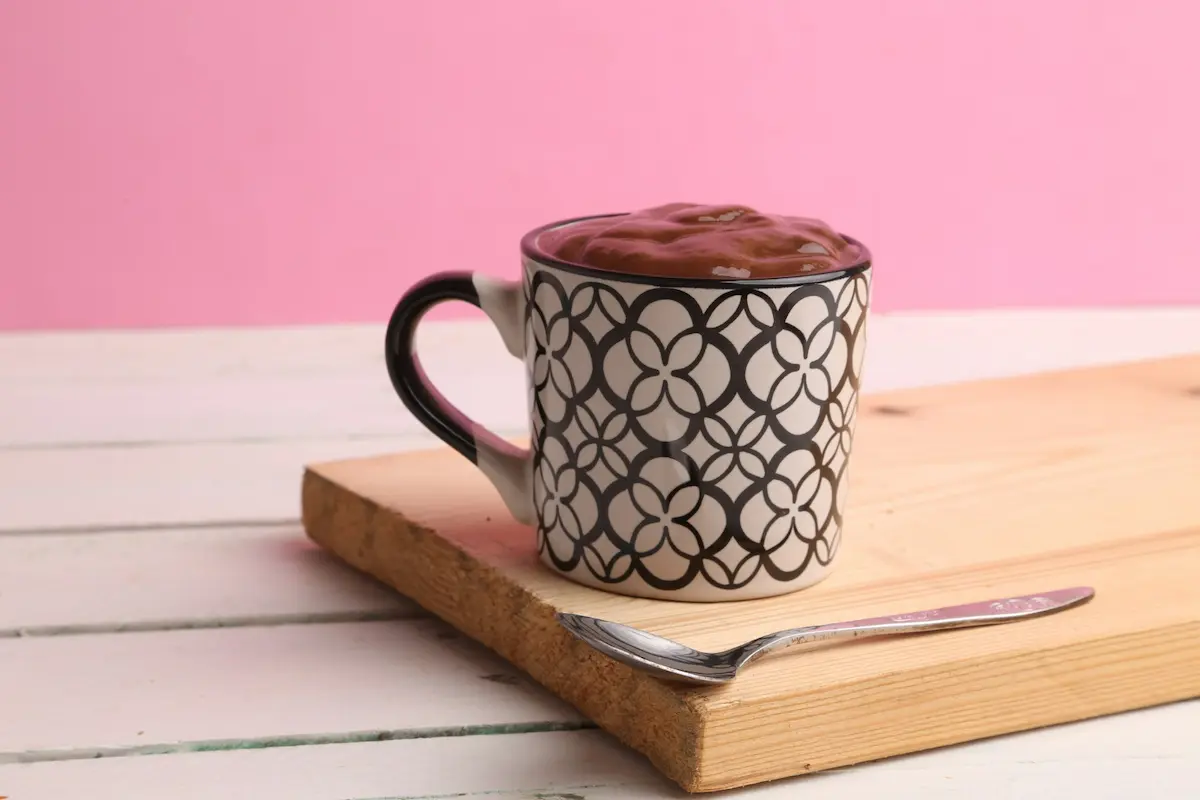 una taza rosa llena de chocolate caliente