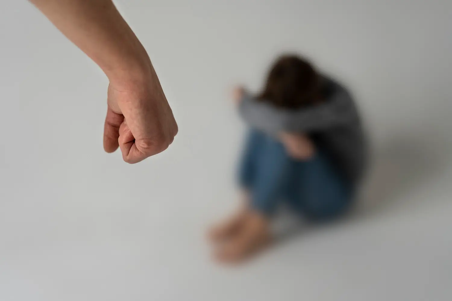 brazo de hombre delante a mujer maltratada