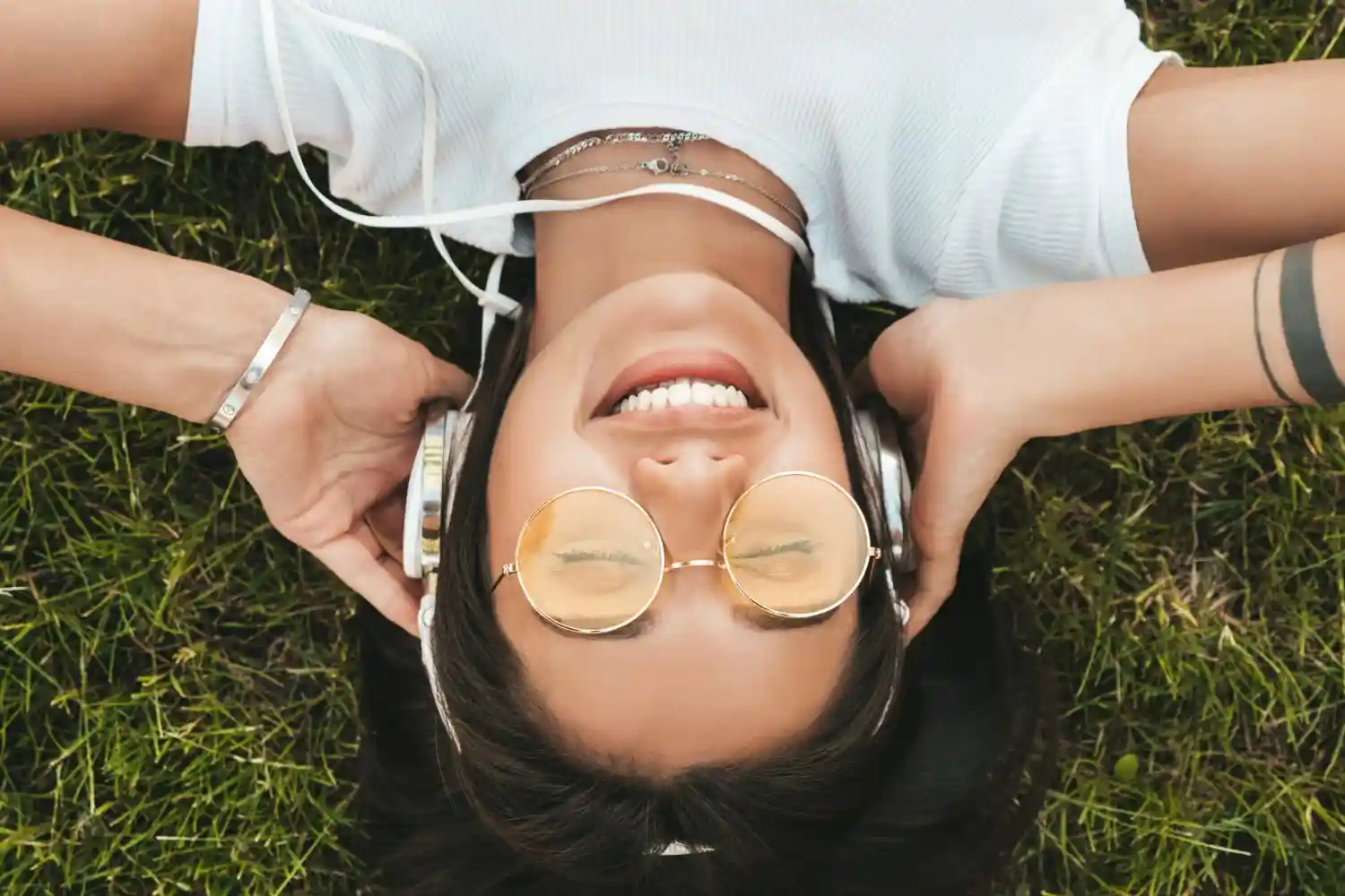chica escucha musica sobre cesped