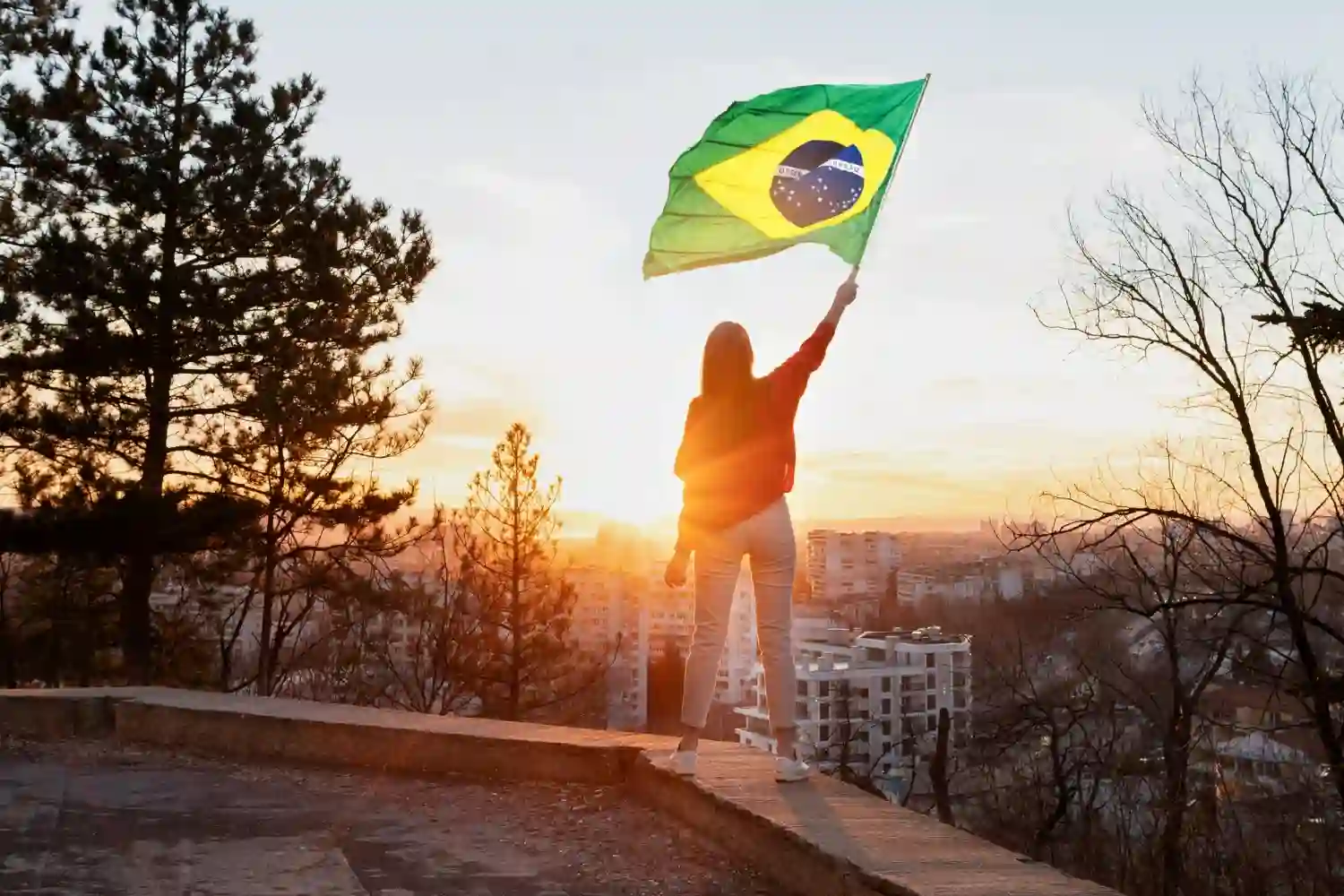 chica mueve bandera de brasil en el ocaso