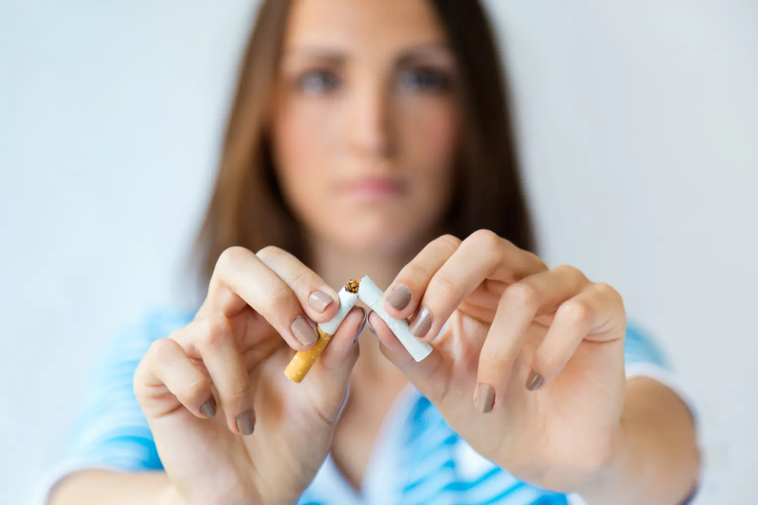 chica rompe cigarro con las manos