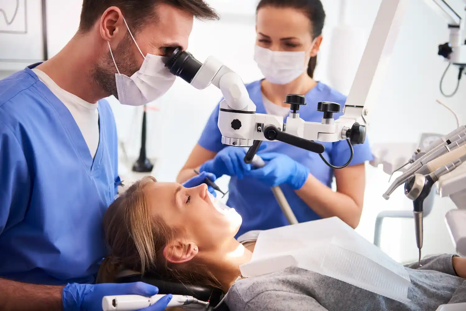 dos dentistas realizan endodoncia a mujer