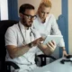 dos medicos mirando cosas en una tablet