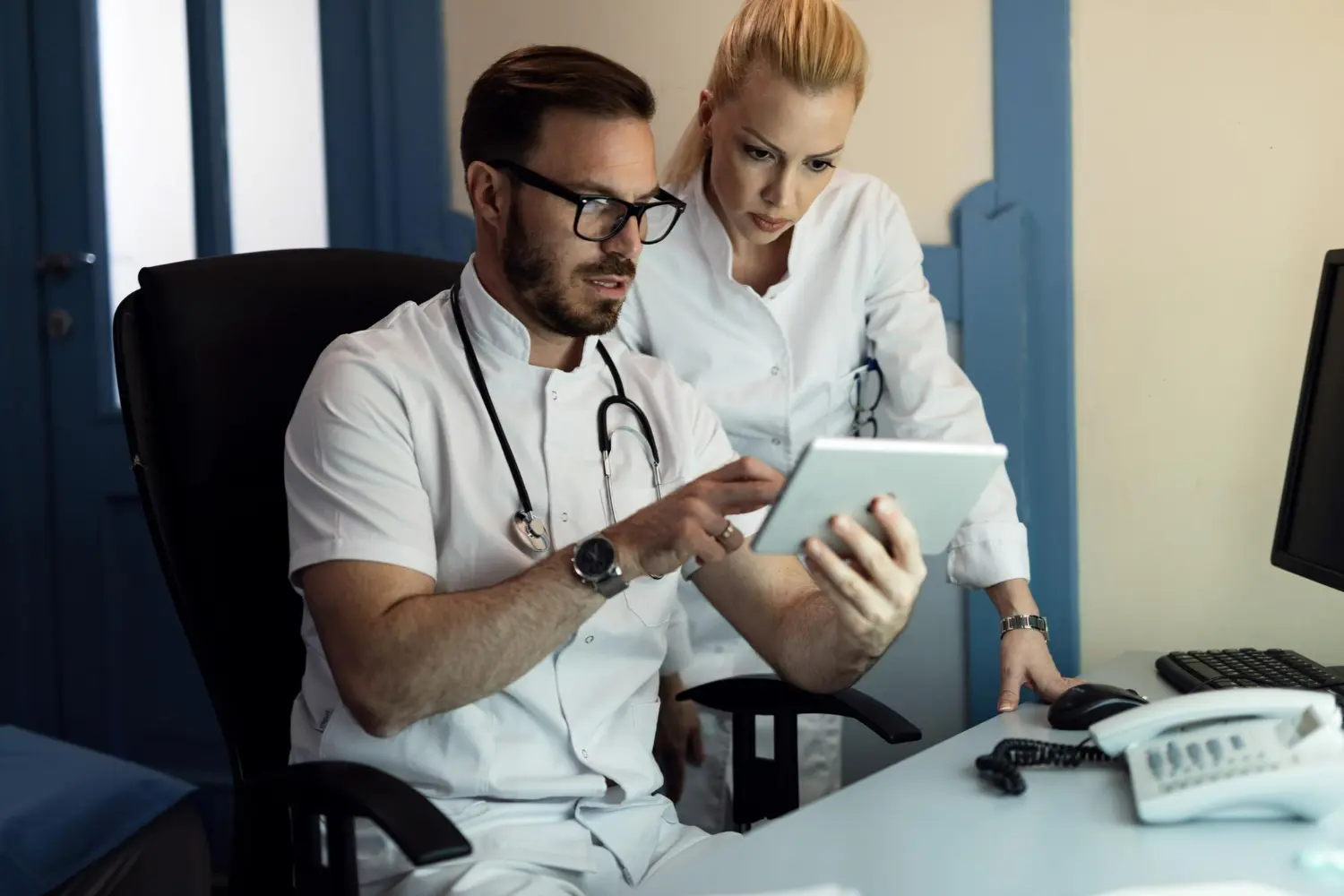 dos medicos mirando cosas en una tablet
