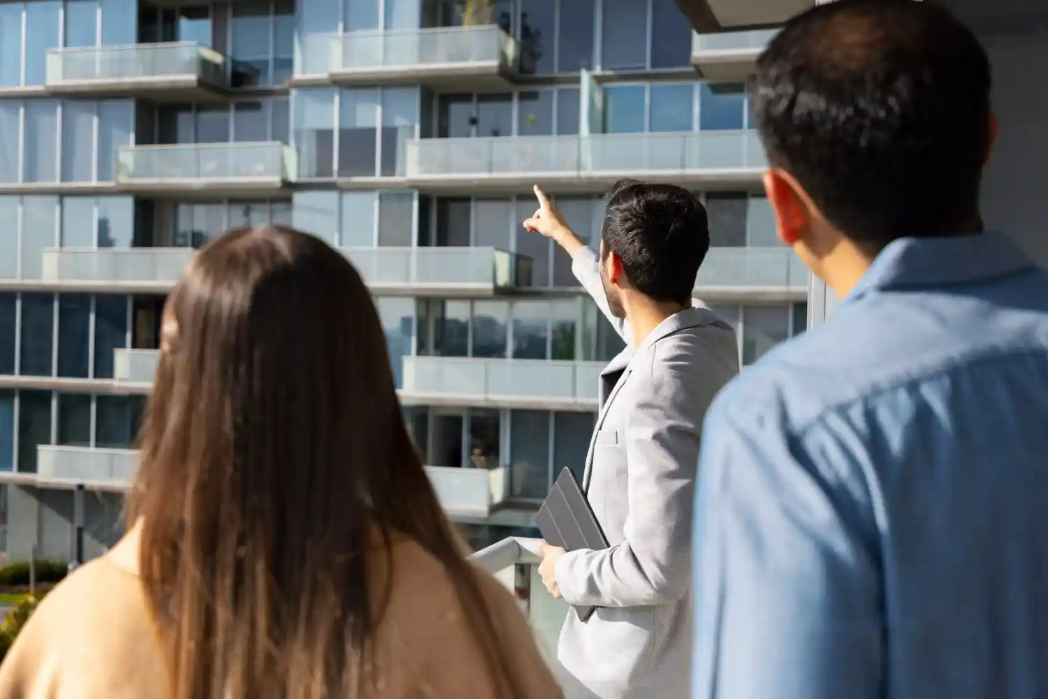 hombre indica un condominio a pareja