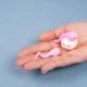 mano con piccolo ovulo e due pupazzetti rosa