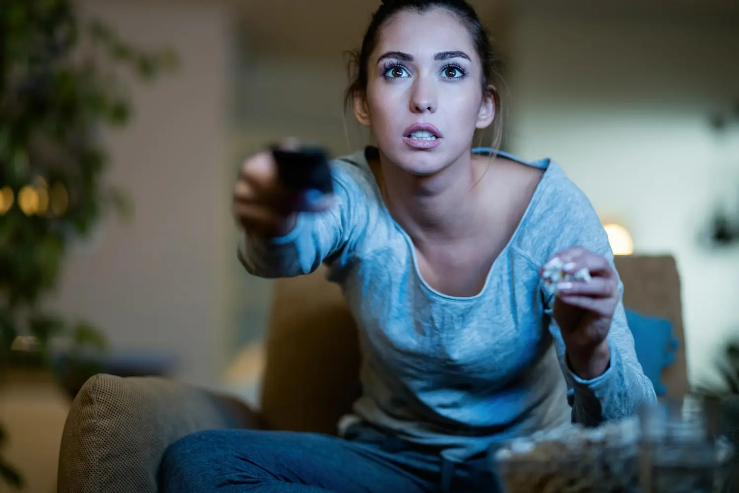 mujer atenta con mando delante tv