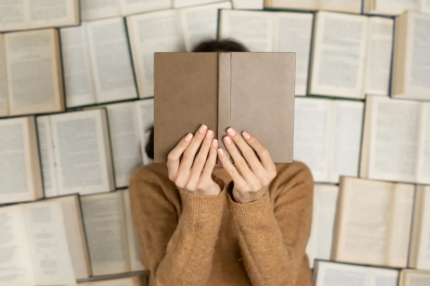 mujer con libro tapando su cara