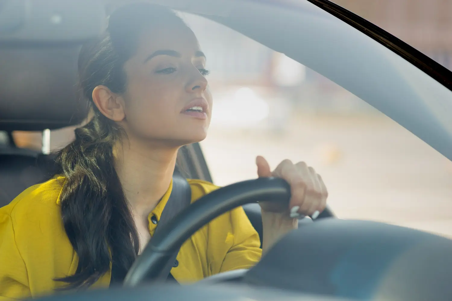 mujer intenta a conducir un coche mira palante